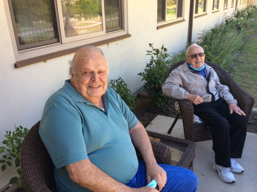 Two men sitting on the porch together